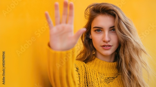Beautiful young blonde woman on the street showing stop gesture with her palm
