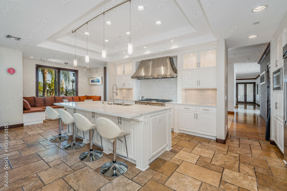 a kitchen has a huge center island with chairs and marble counter tops a kitchen has a huge center island with chairs and marble counter tops