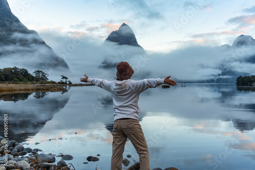 Female tourist enjoying with the Milford sound with Mitre peak and foggy on the lake view at New Zealand