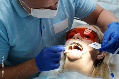 Dentist examines condition of teeth with help of medical instruments in patient's girl. Primary reception. Dental clinic. Health care. High quality photo