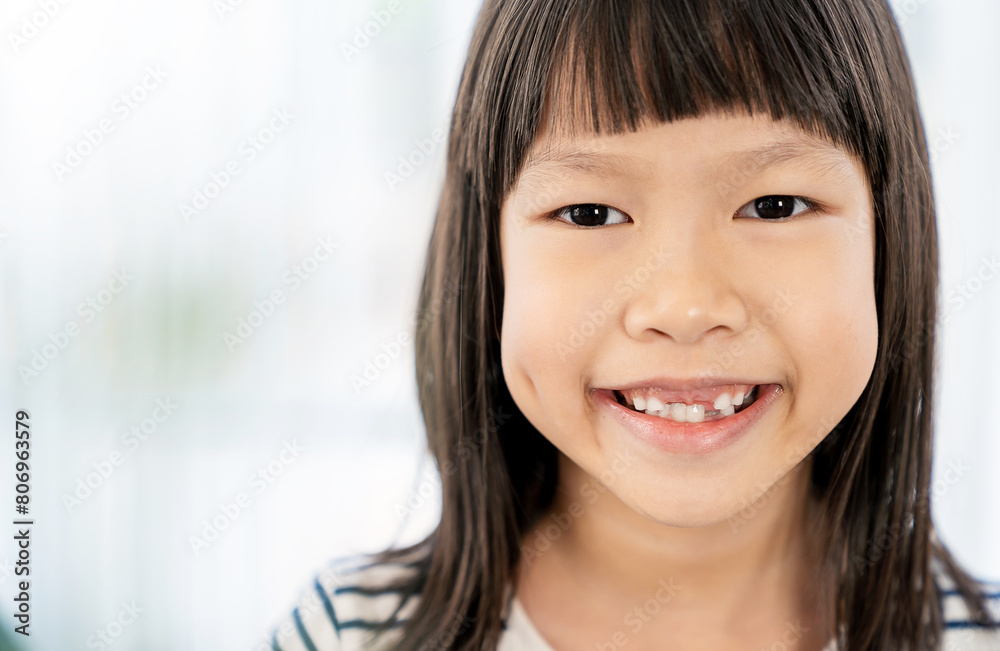 Close up portrait of young fun smart happy little cute asian girl with milk teeth studio shot. Education for elementary kindergarten, back to school, dental health care concept Close up portrait of young fun smart happy little cute asian girl with milk teeth studio shot. Education for elementary kindergarten, back to school, dental health care concept