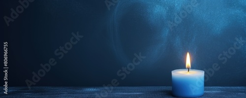 Indigo background with white thin wax candle with a small lit flame for funeral grief death dead sad emotion with copy space texture for display 
