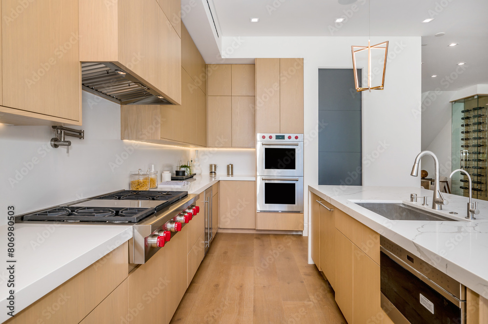 a large, clean kitchen with modern style counter tops and a stove a large, clean kitchen with modern style counter tops and a stove