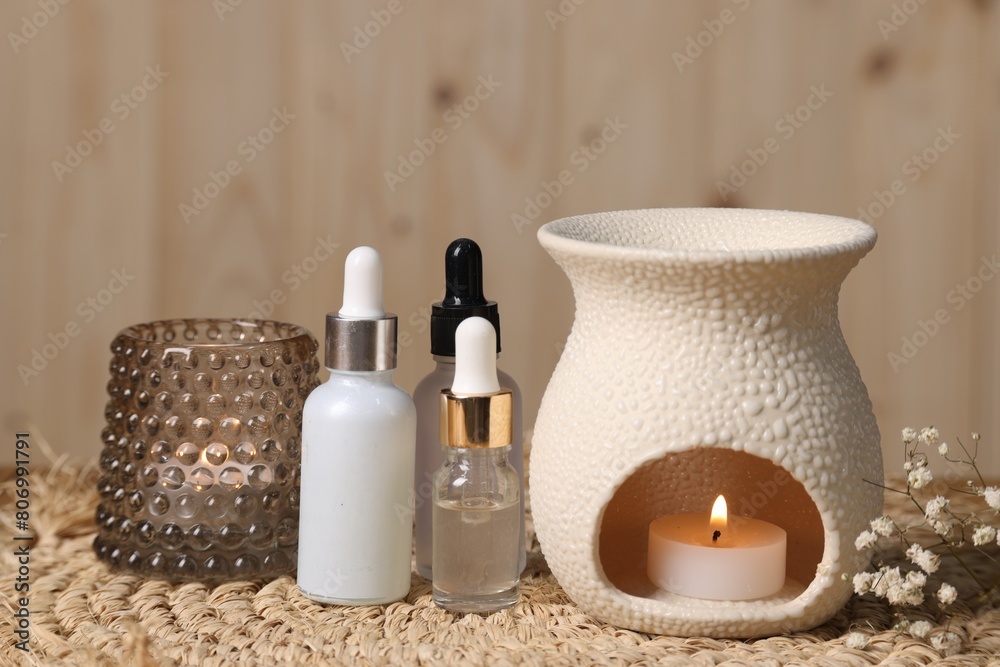 Different aromatherapy products and burning candles on table Different aromatherapy products and burning candles on table