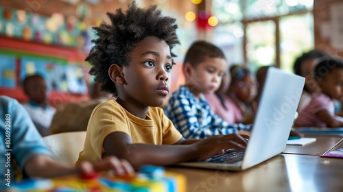 Curly hair American African black boy using laptop in classroom