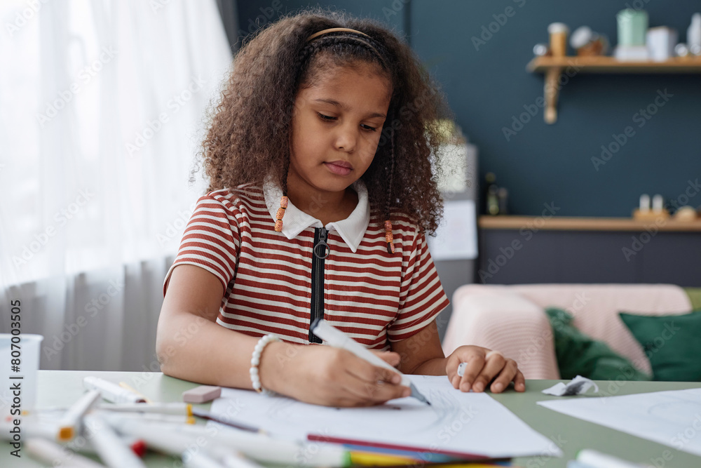 Portrait of little Black girl drawing picture with pencils sitting at table at home, copy space Portrait of little Black girl drawing picture with pencils sitting at table at home, copy space