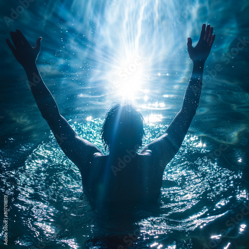 Man who has been baptized raising his arms in joy photo
