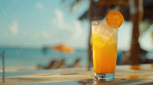 Close up on water drop beside blur orange cocktail glass and bar beach view