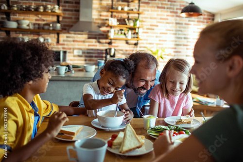 Happy diverse family enjoying breakfast together in a cozy kitchen
