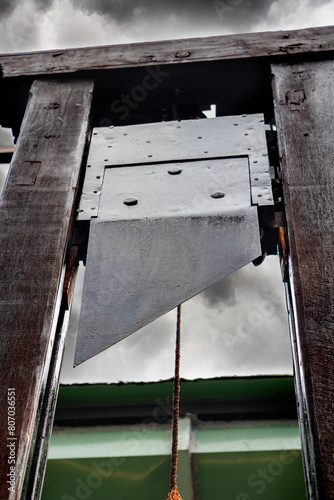 Guillotine under a sky of storm clouds photo