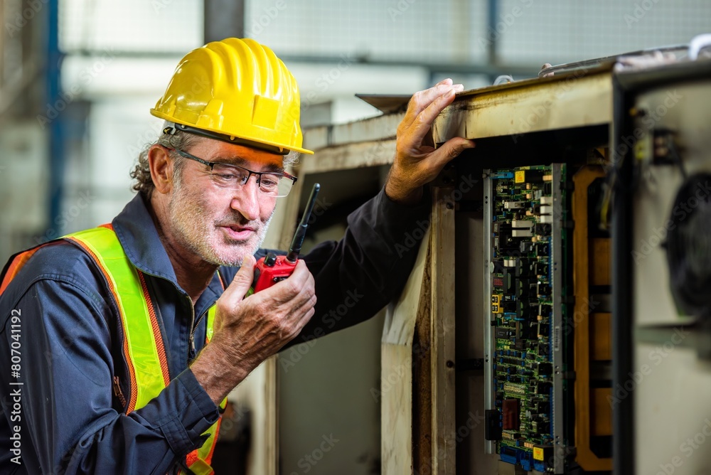 man engineer technician worker talk call by use mobile radio walkie talkie communicate speak to service technician. worker in uniform helmet safety and inspection check control old machine in factory man engineer technician worker talk call by use mobile radio walkie talkie communicate speak to service technician. worker in uniform helmet safety and inspection check control old machine in factory