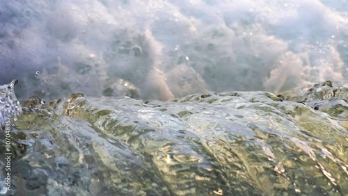 Slow motion of clear river stream. Close up of flowing waterfall. Water splashing scene. 