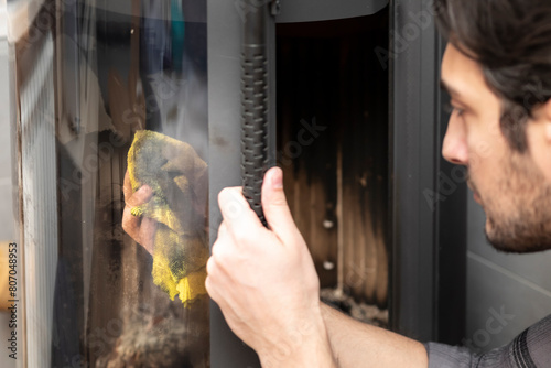 A man cleans a fireplace after the end of the heating season	