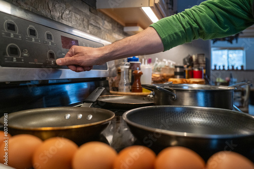 Man cooking fggs at home in his kitchen