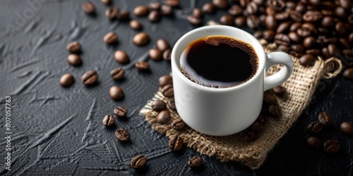 A bold and beautiful cup of black coffee is placed on a rustic black background  creating a captivating blend of elegance as it is surrounded by coffee beans