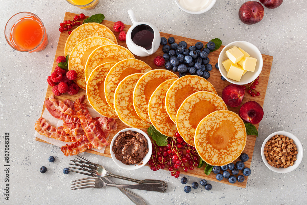 american pancake board with bacon berries maple syrup butter