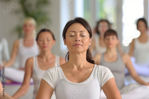 Attractive blond Asian woman attending yoga course with group