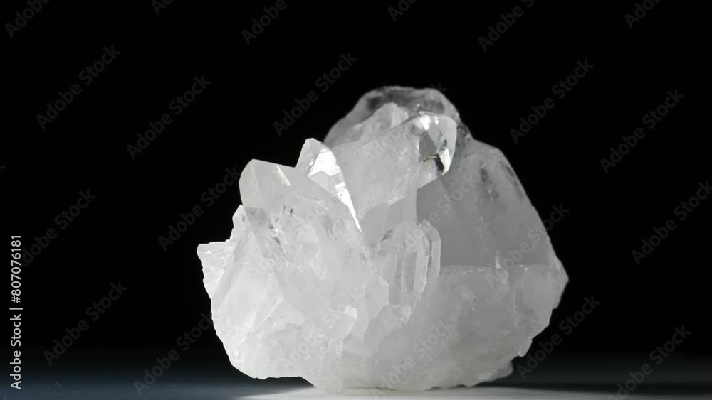 Clear quartz crystal rotating slowly against a black background. Clear quartz crystal rotating slowly against a black background.