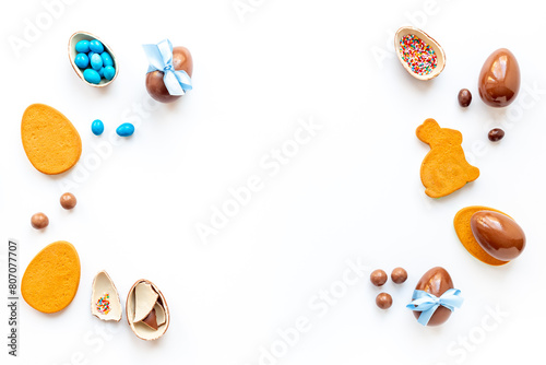 Happy Easter card. Chocolate Easter eggs in blue ribbon with bunny cookies