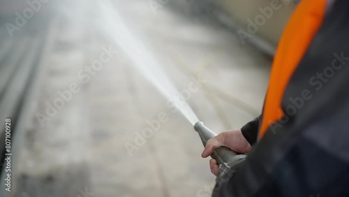 Fireman using a high pressure hose for fire fighting, pouring water from the pipe in emergency case, accident.