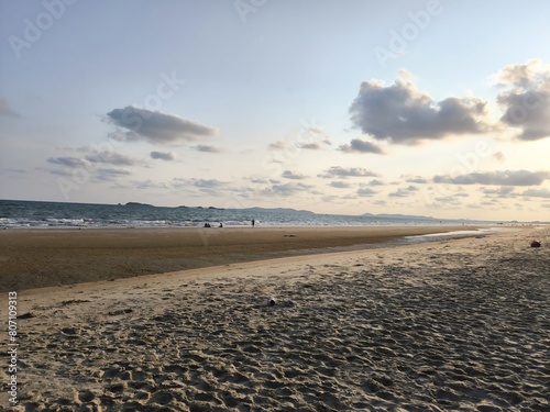The photo shows a beautiful beach with white sand and clear water. Relaxing on the beach and enjoying the sunset is a perfect way to de-stress.