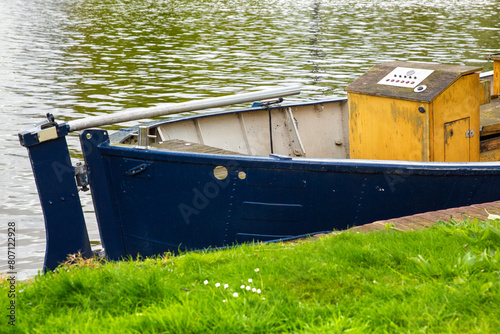 Blue boat anchored along a canal in Amsterdam, Netherlands.