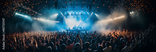 An exhilarating view of an enthusiastic crowd at a live concert, with hands raised, stage lights illuminating the scene, and confetti in the air