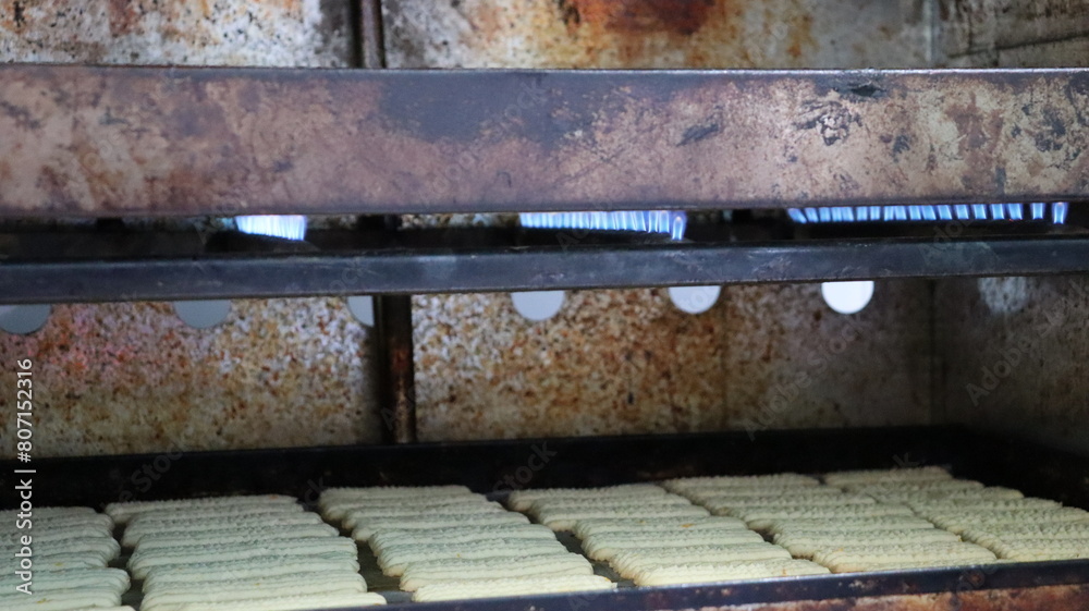 Baking Fresh Butter Cookies: Cookie Dough Extruded from a Press onto a Baking Sheet in Rows Baking Fresh Butter Cookies: Cookie Dough Extruded from a Press onto a Baking Sheet in Rows