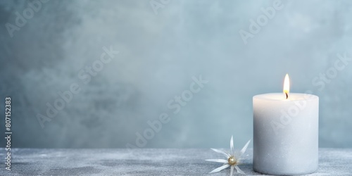 Silver background with white thin wax candle with a small lit flame for funeral grief death dead sad emotion with copy space texture for display products