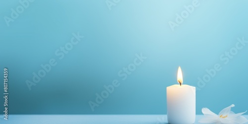 Sky Blue background with white thin wax candle with a small lit flame for funeral grief death dead sad emotion with copy space texture for display 