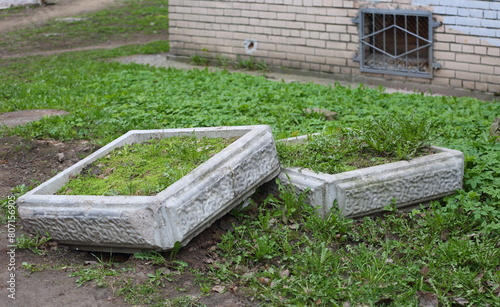 Two shallow square concrete flowerbeds lie on the lawn