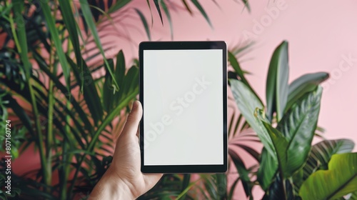 A hand holds a tablet with a white screen. Mockup art.
