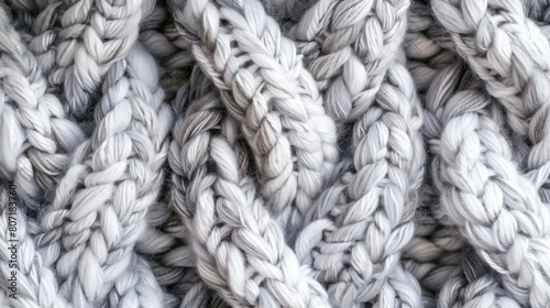 Close-up of intertwined gray woolen ropes. Macro shot of twisted fibers.