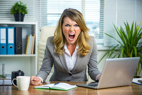 Portrait of angry furious young business woman sitting at the office desk 