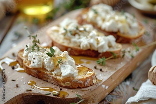 Close up of wooden board with goat cheese honey thyme on toast