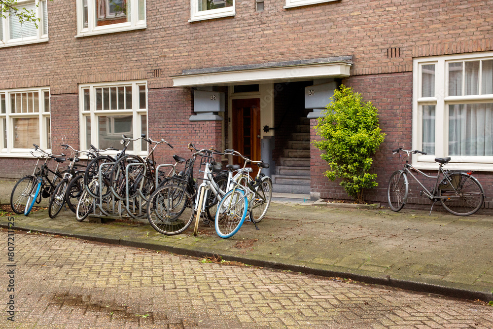 Bicycles parked in a row in front of a house in Amsterdam, Netherlands.