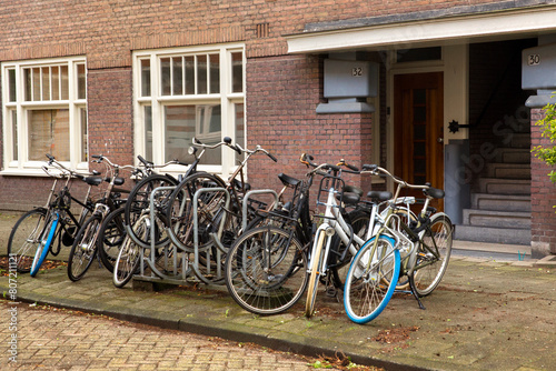 Bicycles parked in a row in front of a house in Amsterdam, Netherlands.