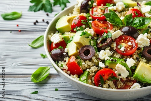 Homemade quinoa salad with feta tomatoes avocado olives on white rustic background Vegan clean eating photo