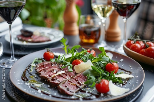 Italian main dish Beef tagliata with arugula cherry tomatoes Grana Padano and balsamic reduction From Emilia Romagna Table presentation