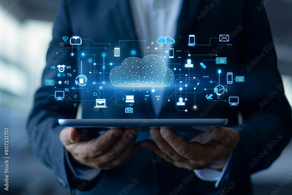 Fototapeta premium Cloud computing integration: businessman with tablet and technology graphics