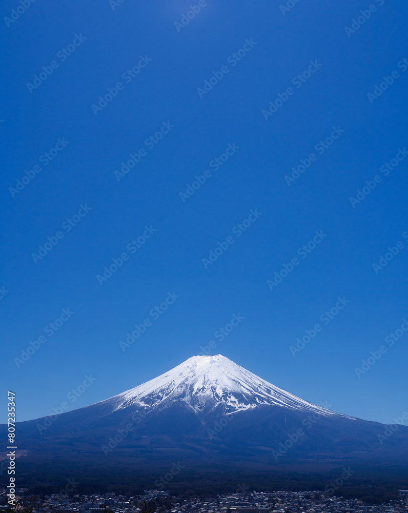 A cloudless sky stretching for miles, alongside the majestic Mount Fuji, a landmark of Japan.
