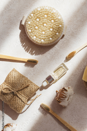 Set of eco cosmetics products and tools. Bottle of essential oil or serum, handmade soap, bamboo toothbrush, natural wooden brush on pastel background with shadow.