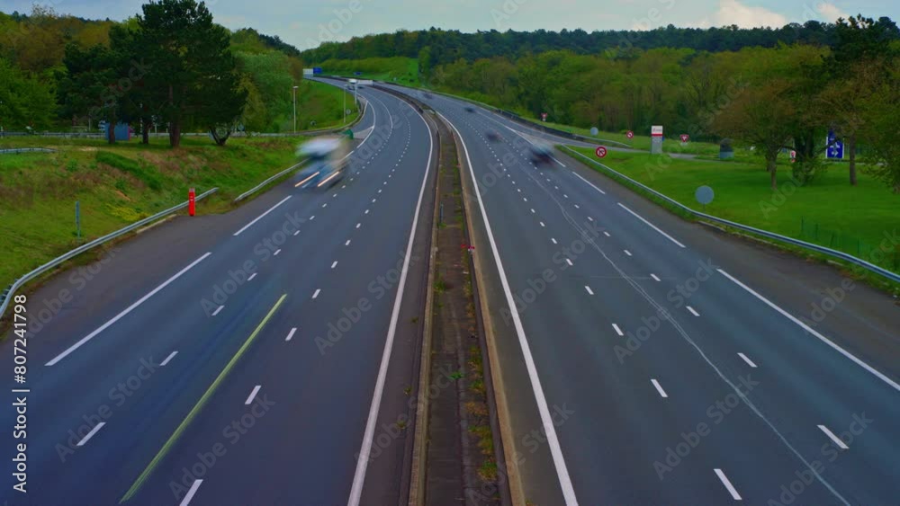 Time lapse view of cars driving along roadway in rush hour in France. Toll road near Paris Time lapse view of cars driving along roadway in rush hour in France. Toll road near Paris