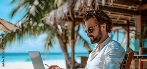 Hardworking person on vacation, focused on phone and laptop without taking a break