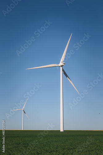 windmills of wind energy in the middle of the countryside with beautiful colors and clear blue sky, renewable energy © Maria de la Pe/a