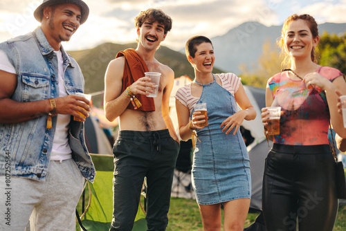 Circle of friends laughing and drinking beers together at a festiva photo