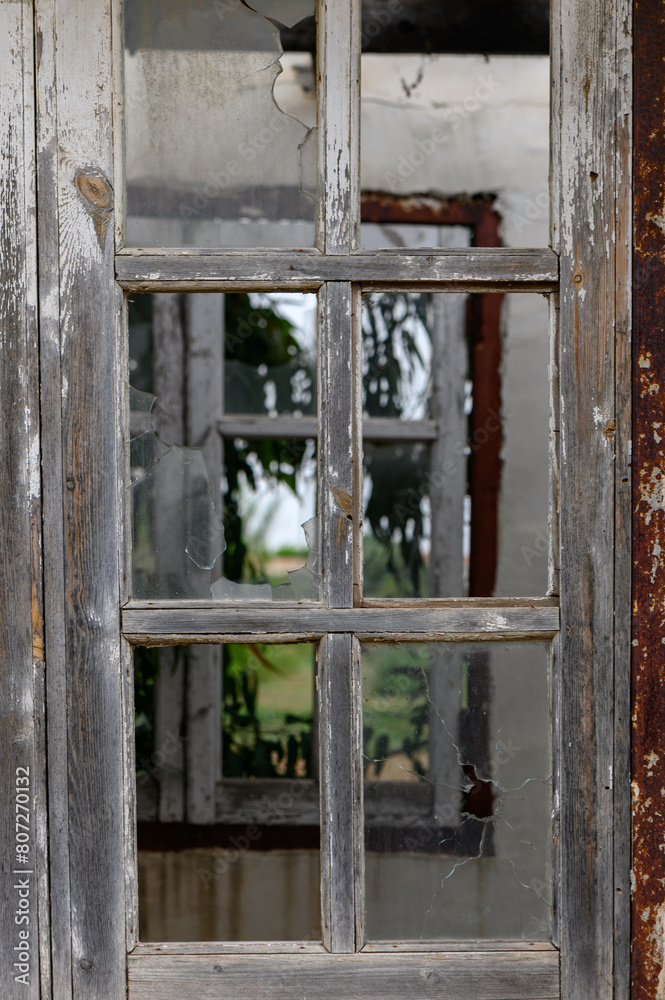 Window with broken glass in old building Wooden window frame with partially broken glass in old abandoned brick building Window with broken glass in old building Wooden window frame with partially broken glass in old abandoned brick building