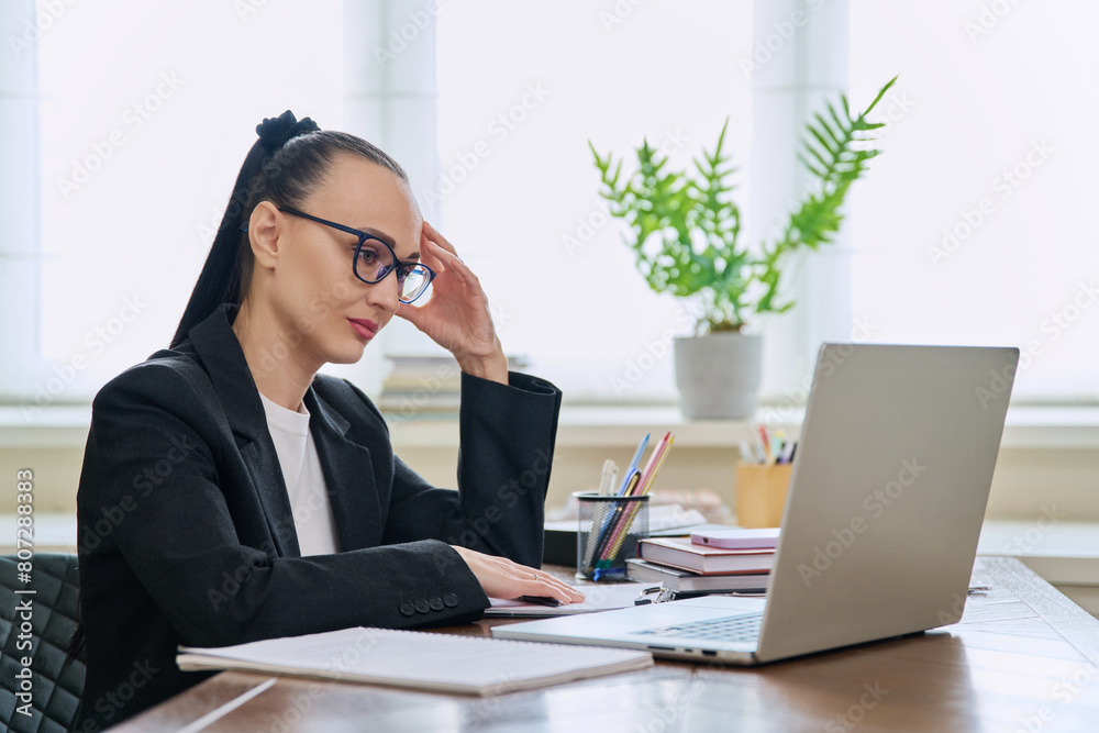 Business woman working in home office at desk with laptop computer Business woman working in home office at desk with laptop computer