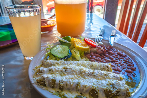 Mexican food, green enchiladas with beans accompanied by water, Mexican fonda food photo