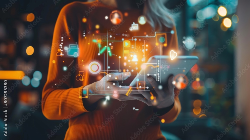Fototapeta premium A woman is holding a tablet with a colorful screen that has a lot of icons